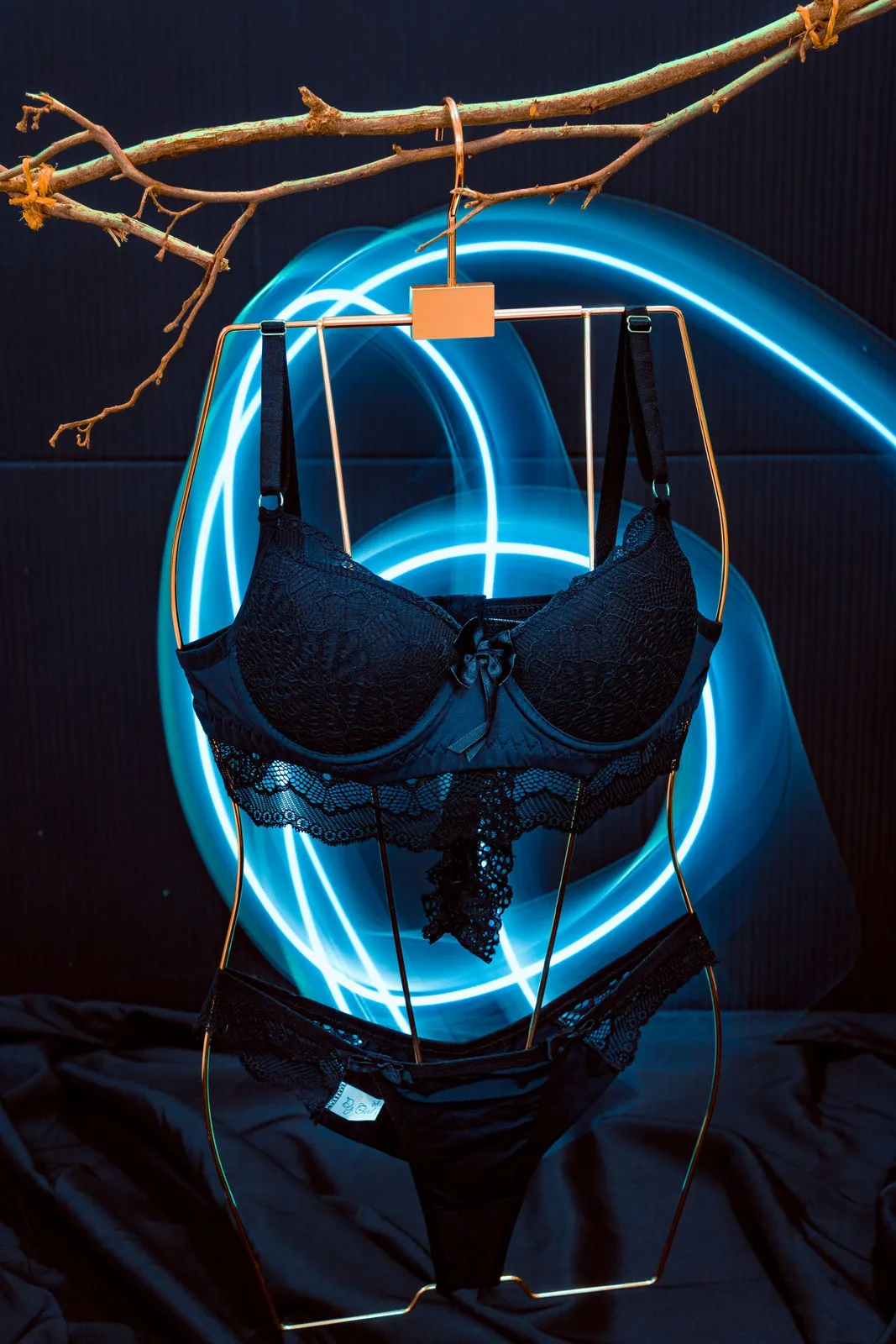 Black lace lingerie set under a blue neon ring